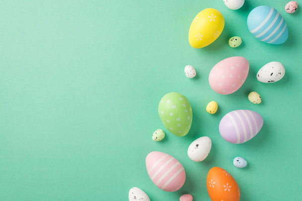 Top view photo of easter decorations multicolored easter eggs on isolated pastel green background with copyspace - Фото, изображение
