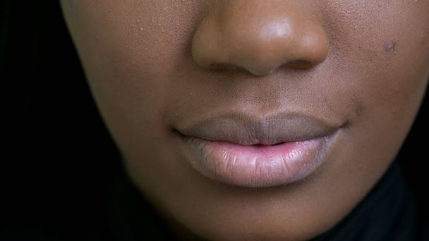 Siyahi bir kız ağzı kapalı, Afrikalı bir kadın makroyla karşı karşıya. - Fotoğraf, Görsel