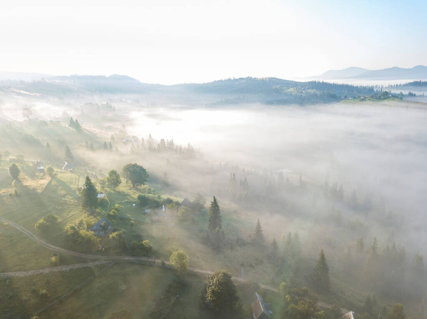 Πρωινή ομίχλη στα Ουκρανικά Καρπάθια βουνά. Αεροφωτογραφία τηλεκατευθυνόμενου. - Φωτογραφία, εικόνα