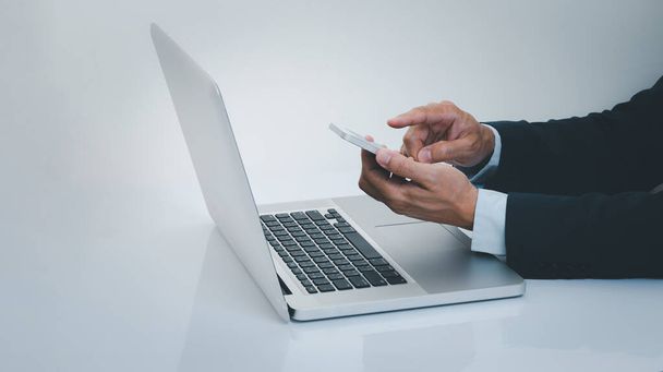 Businessman hand using smartphone with laptop computer. Business and technology concept. - Fotó, kép
