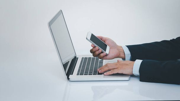 Businessman hand using smartphone with laptop computer. Business and technology concept. - Foto, Bild