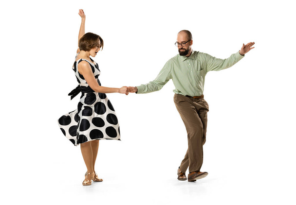Dynamic portrait of couple of dancers in vintage retro style outfits dancing lindy hop dance isolated on white background. Concept of art, action, motion - 写真・画像