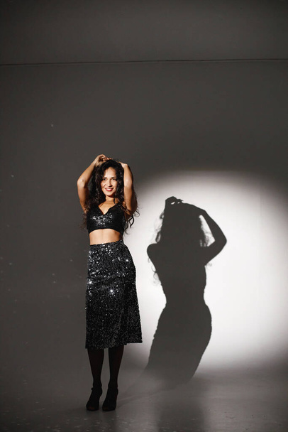 Portrait of caucasian woman salsa dancer under a projectors light - 写真・画像