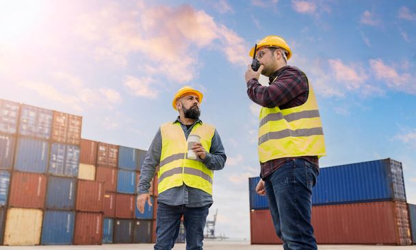 mannen werknemers in container logistiek in haven verzending van merchandise walkie talkie - Foto, afbeelding