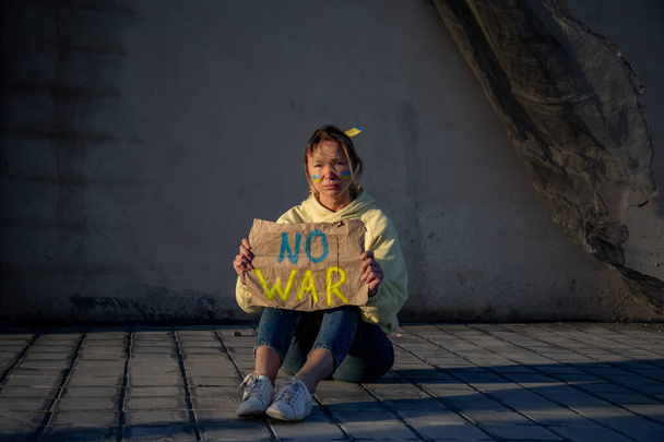 Oekraïense vrouw met een vlag op de wang en geen oorlogsteken  - Foto, afbeelding