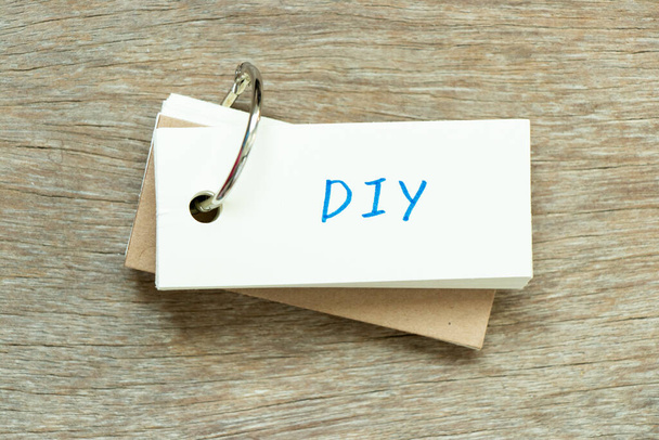 Tarjeta flash con la palabra de escritura DIY (abreviatura de hacerlo usted mismo) sobre fondo de madera - Foto, imagen