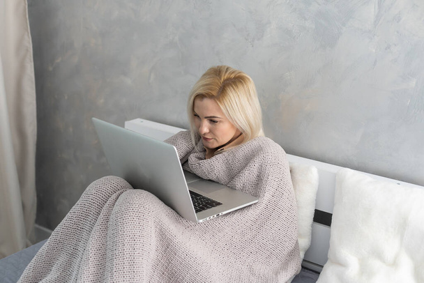 Verveelde vrouw rustend en liggend op de bank pauzeren, film kijken, thuis op laptop werken in de woonkamer. Luie weekend. - Foto, afbeelding