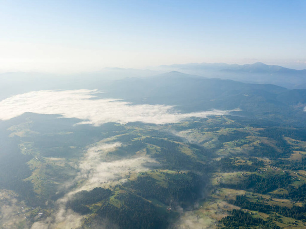 Wysoki lot w górach Karpat Ukraińskich. Mgła w dolinie. Widok drona z powietrza. - Zdjęcie, obraz