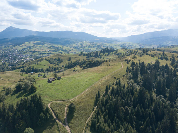 Green mountains of Ukrainian Carpathians in summer. Coniferous trees on the slopes. Aerial drone view. - Fotó, kép