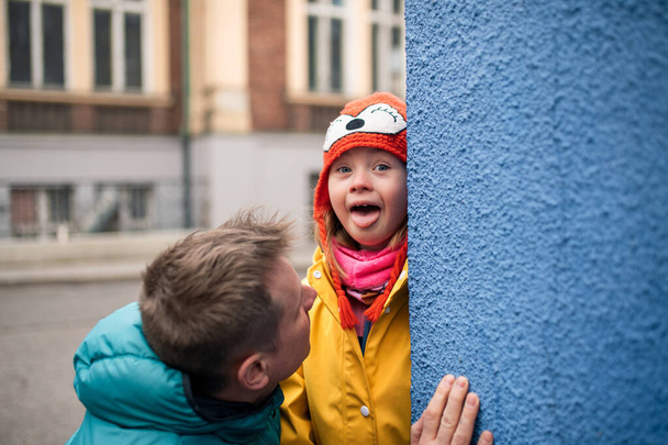 Father with his little daughter with Down syndrome outdoors in street in winter - Foto, Bild