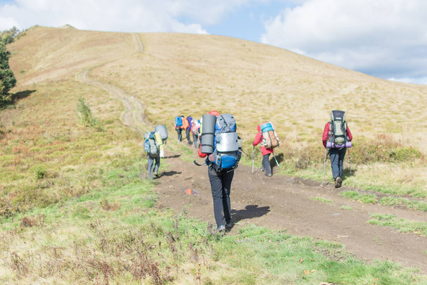 Группа людей с рюкзаками, путешествующих по горам. - Фото, изображение