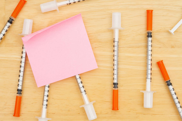 Aiguille de vaccin jetable sur le bureau avec une note collante pour le vaccin ou un message covide - Photo, image