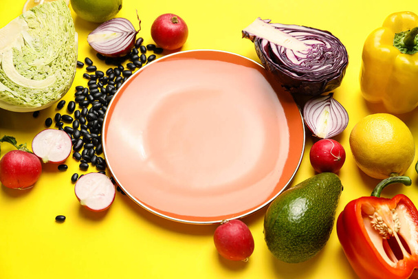 Összetétel tányérral és összetevőkkel a mexikói zöldségsalátához sárga alapon - Fotó, kép