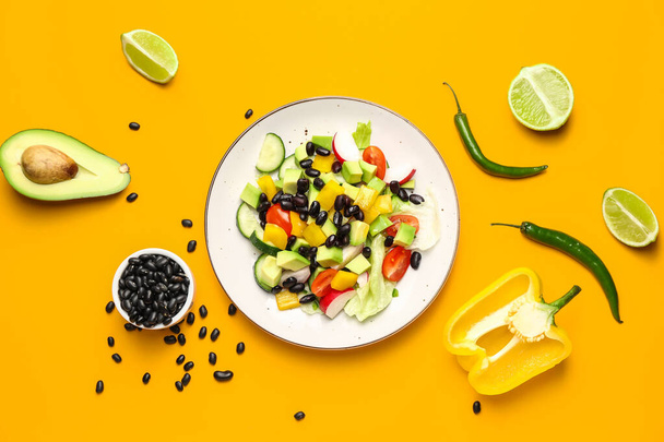 Talíř s chutným mexický zeleninový salát a ingredience na barevném pozadí - Fotografie, Obrázek