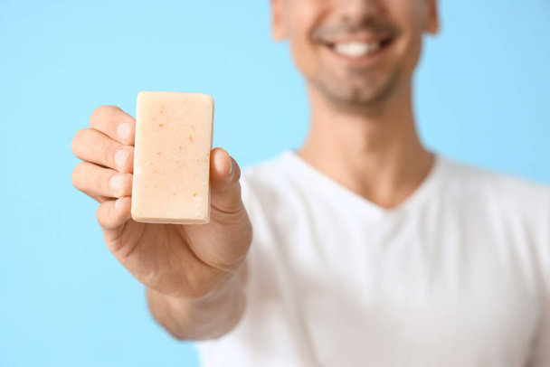 Young man with soap on blue background, closeup - Photo, Image