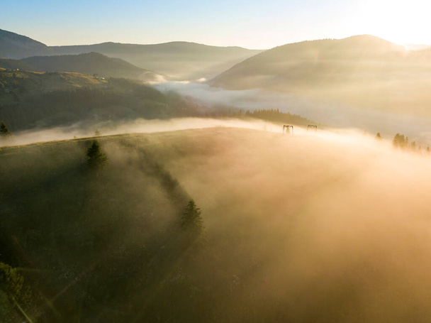 Промені ранкового сонця через туман у горах. Повітряний вигляд безпілотника
. - Фото, зображення