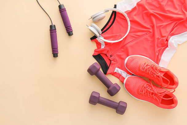 Sportuitrusting, schoenen, kleding en hoofdtelefoon op kleur achtergrond - Foto, afbeelding