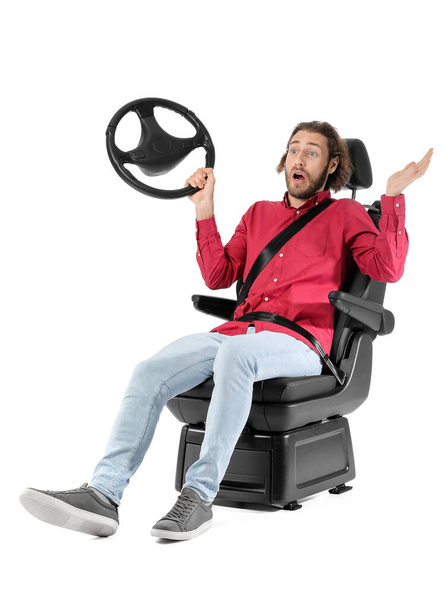 Шокированный мужчина в автомобильном кресле и с рулем на белом фоне - Фото, изображение