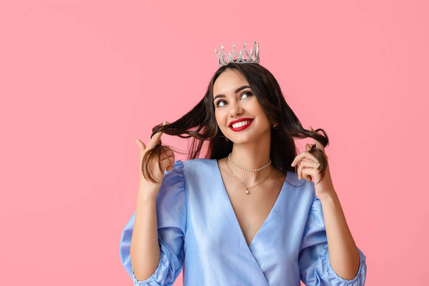 Beautiful young woman in stylish dress and tiara on pink background - Photo, Image