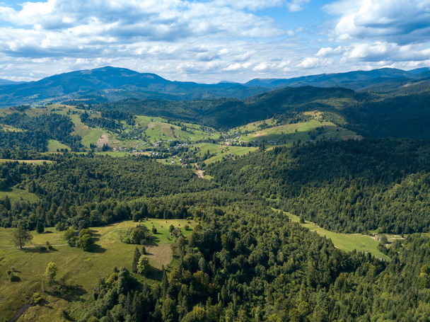 Green mountains of Ukrainian Carpathians in summer. Coniferous trees on the slopes. Aerial drone view. - Fotoğraf, Görsel
