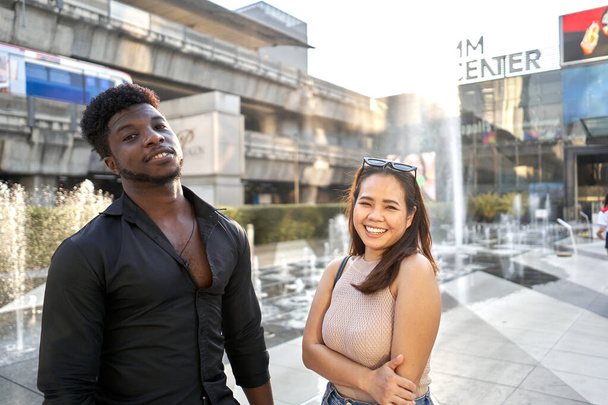 Two multiethnic friends posing friendly in a shopping mall - Фото, изображение