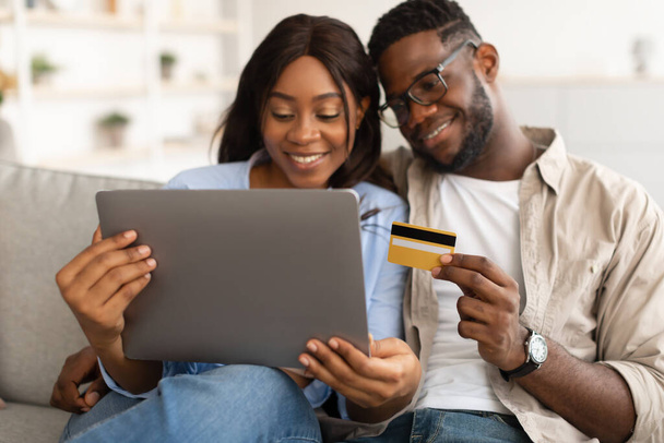 Black couple using pc and debit credit card at home - Photo, Image