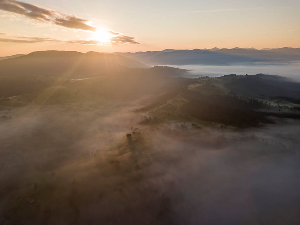 Sunrise over the fog in the Ukrainian Carpathians. Aerial drone view. - Фото, изображение