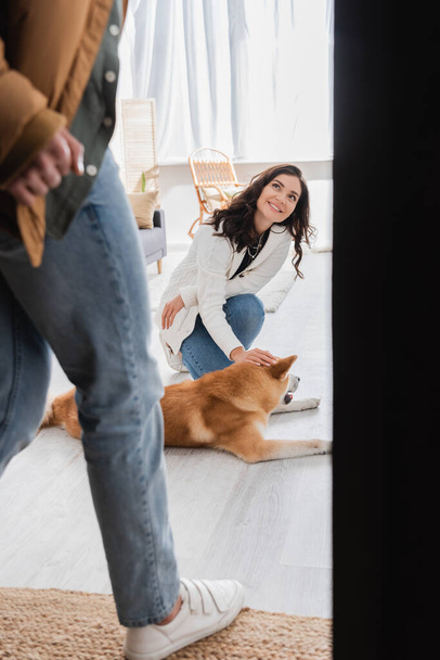 femme heureuse câlinant akita inu chien et regardant le petit ami flou  - Photo, image