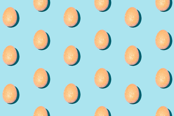Pattern made of orange eggs on pastel blue background. Minimal Easter or food concept. - Fotoğraf, Görsel