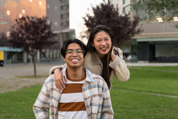 Boldog ázsiai tini pár diák barátok ölelik egymást pozitív érzelmek - Fotó, kép