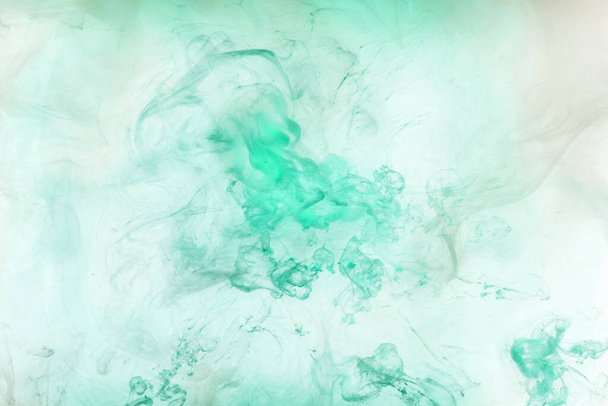 Green smoke on white ink background, colorful fog, abstract swirling emerald ocean sea, acrylic paint pigment underwater - Фото, зображення