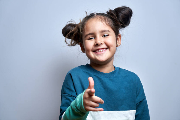 Ritratto di amichevole positivo giovane ragazza sceglie voi, bambino punta il dito contro la fotocamera isolata su sfondo bianco - Foto, immagini