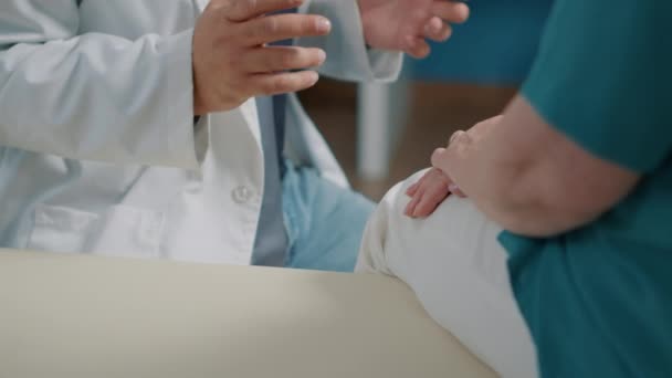 Mieslääkäri lohduttaa vanhempi potilas lääkekaapissa - Materiaali, video