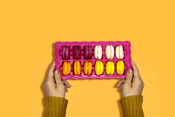 closeup mão mulher segurando uma caixa de francês colorido Macarons Cookies  - Foto, Imagem