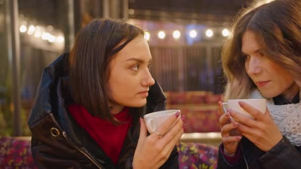 dos mujeres felices pasan tiempo juntas en un café, restaurante, noche romántica a la luz de las velas, ambiente ligero, estilo de vida. bebiendo café juntos. - Metraje, vídeo
