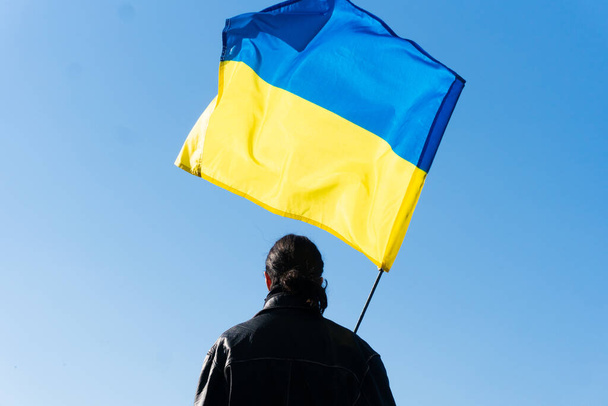 若い男はフィールドにウクライナの旗を保持しています。愛国者 - 写真・画像