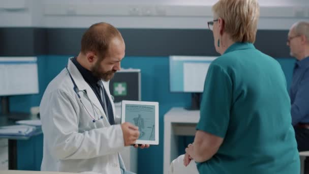 Mężczyzna lekarz pokazując człowieka szkielet ilustracja na tablecie cyfrowym - Materiał filmowy, wideo
