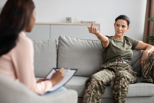 Veterani e terapia mentale. Soldato donna mostrando dito medio a psicoterapeuta - Foto, immagini