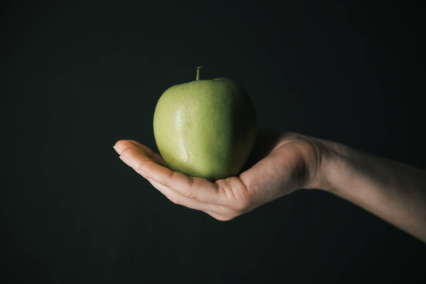 green apple in hands of woman - Фото, изображение