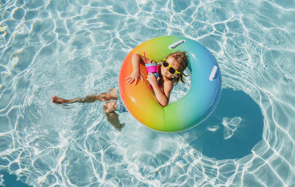 Summer vacation. Summertime kids weekend. Boy in swiming pool. Child at aquapark. Funny boy on inflatable rubber circle. - Foto, Imagen