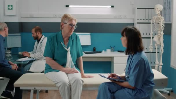 Mujer mayor conversando con asistente médico - Metraje, vídeo