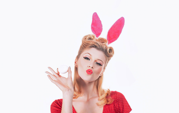 Easter egg hunting - Easter day concept. Isolated white background. Pin up Easter. Bunny ears concept. Woman wearing a mask Easter bunny and looks very sensually. Hunting eggs. - Zdjęcie, obraz