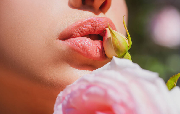 Sexy Lips. Beauty Red Lips Makeup Detail. Lips with spring flowers closeup. Beautiful woman lips with rose. - Fotoğraf, Görsel