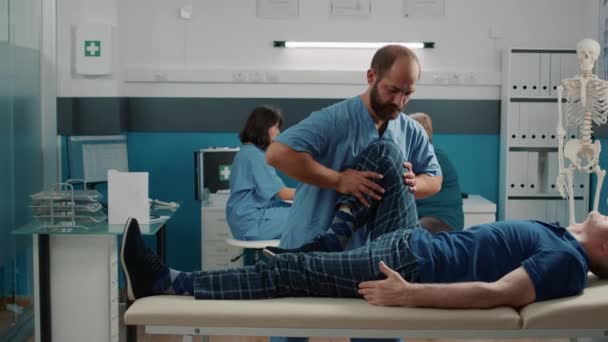 Praticien masculin faisant des jambes lever la procédure pour craquer les os - Séquence, vidéo