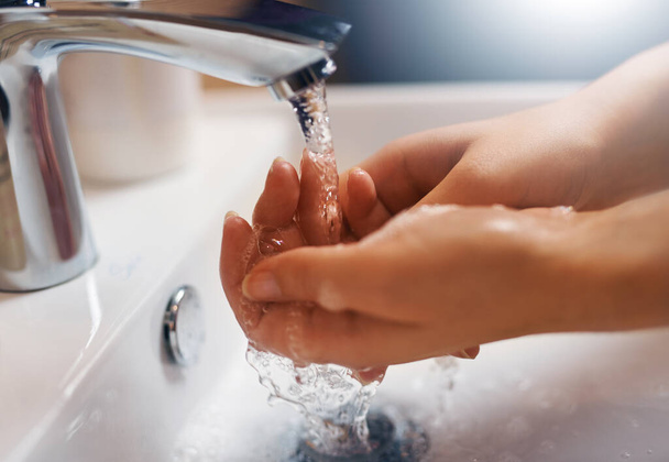 Keeping hands clean. Closeup shot of a hands being washed at a tap. - 写真・画像