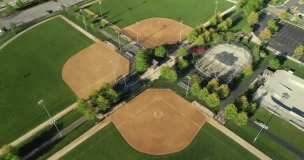 Vista aérea de un complejo de juegos multiuso con campos de fútbol / lacrosse, jaulas de bateo, parque de skate y campos de softbol con luces. - Metraje, vídeo