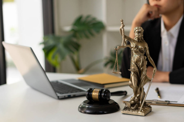 Ügyvéd az irodában Gail Brass-szel. Igazságügyi szobor és ügyvéd dolgozik a laptopon és a női bíró kalapácsán, vagy Eustitián. Az igazság római istennője, jogi fogalmak. - Fotó, kép