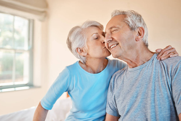 Ти найкращий. Обрізаний знімок лагідної старшої жінки цілує свого щасливого чоловіка на щоці в будинку престарілих
. - Фото, зображення