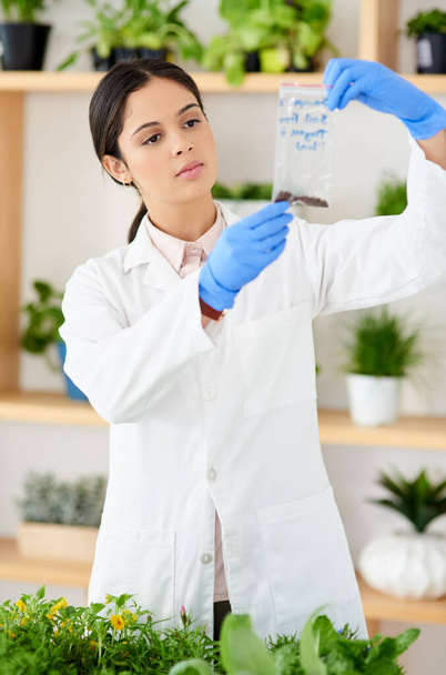 Ill send these off for testing. Shot of a young scientist working with plant samples in a lab. - Fotó, kép