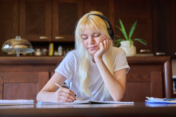 Portrait of a teenage student girl in headphones studying at home - Valokuva, kuva